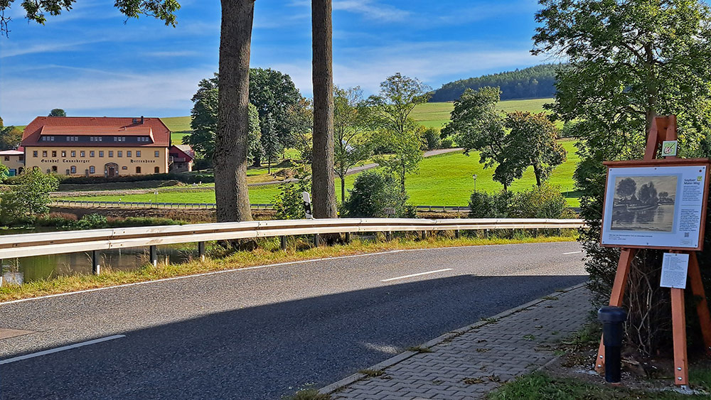 Bundesstraße mit Staffelei , im Hintergrund der Teich und Häuser